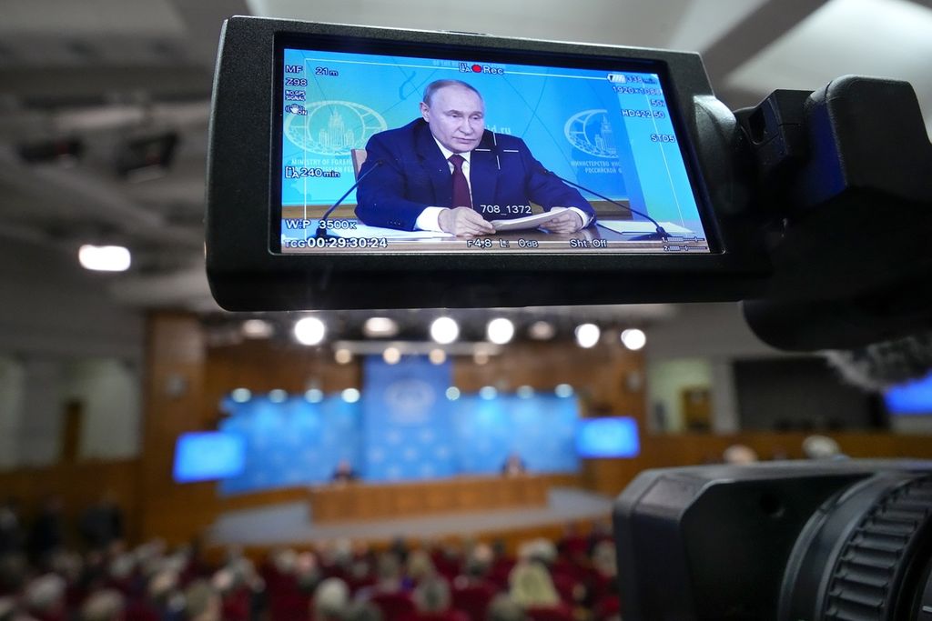 Presiden Rusia Vladimir Putin terlihat di layar kamera saat ia tengah berbicara dalam sebuah pertemuan di Kementerian Luar Negeri Rusia di Moskwa, Jumat (14/6/2024).  