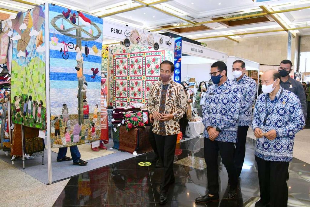 Presiden Joko Widodo meninjau pameran kerajinan Inacraft, Rabu (23/3/2022), di JCC, Jakarta, Rabu (23/3/2022). Menteri Pariwisata dan Ekonomi Kreatif Sandiaga Uno (kedua dari kiri), Menteri Perdagangan M Luthfi (ketiga dari kiri) dan Ketua Asosiasi Eksportir dan Produsen Handicraft Indonesia (Asephi) Muchsin Ridjan (paling kanan) mendampingi.