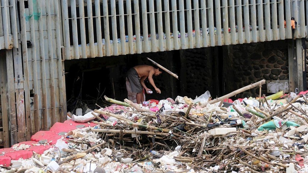 Warga mencari sampah yang masih memiliki nilai jual di Pintu Air Manggarai, Jakarta Selatan, Jumat (5/4/2019).