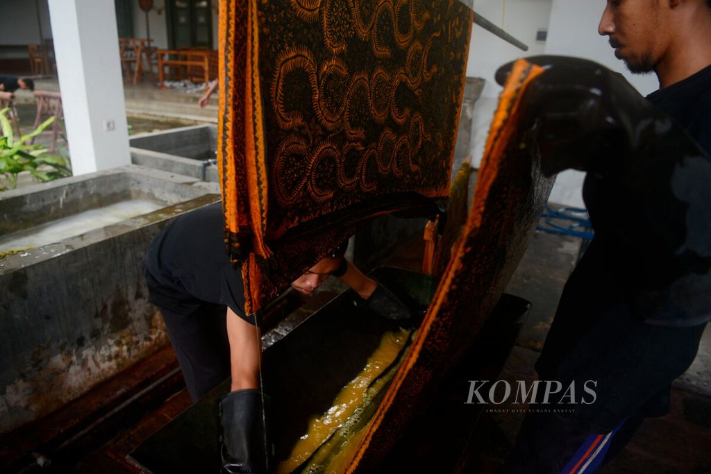 Pekerja memproses pewarnaan kain batik tulis di Rumah Merah, Pecinan Lasem, Kabupaten Rembang, Jawa Tengah, Rabu (26/1/2022). Kerajinan batik ini masih bertahan sebagai salah satu industri rumahan yang menghidupkan perekonomian warga sekitarnya.