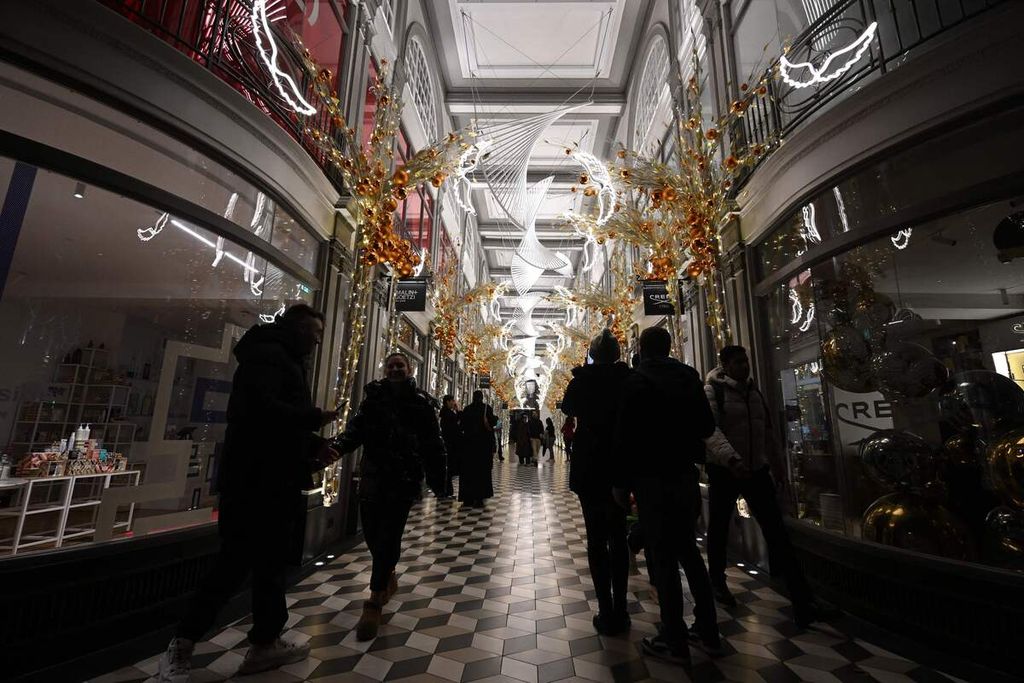 Warga berjalan di Quadrant Arcade, Regent Street, yang dihiasi lampu-lampu natal di London, Inggris, 11 Desember 2023. 