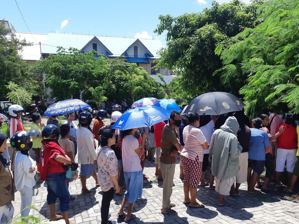Di bawah terik matahari, warga mengantre untuk mendapatkan kupon pembelian beras murah dalam operasi pasar yang digelar Perum Bulog di Kota Kupang, NTT, Senin (13/3/2023).