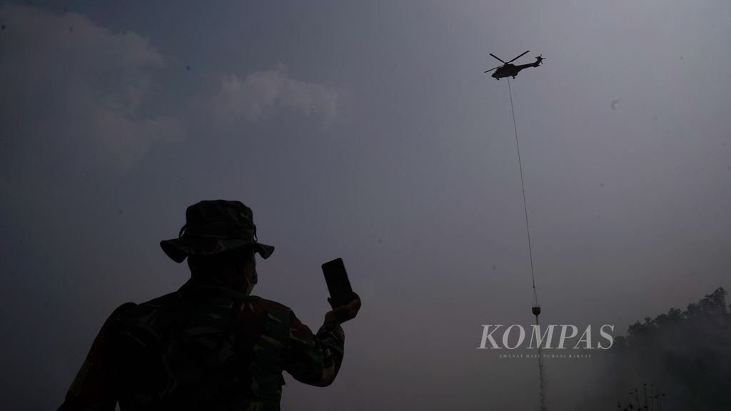 Siluet prajurit TNI AD mengabadikan helikopter BNPB dalam pengeboman air memadamkan kabakaran di TPA Sarimukti, Kecamatan Cipatat, Kabupaten Bandung Barat, Jawa Barat, Sabtu (26/8/2023). 