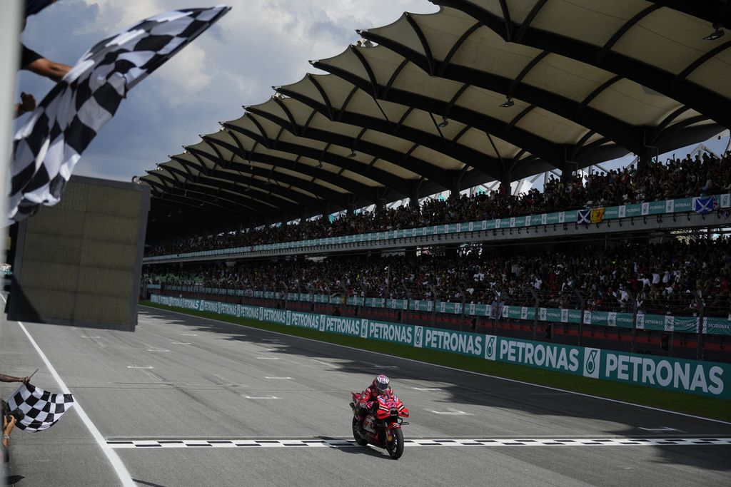 Pebalap tim Ducati, Enea Bastianini, melewati garis finis pada balapan utama MotoGP seri Malaysia di Sirkuit Sepang, Minggu (12/11/2023). Bastianini menjadi pemenang pada ajang itu. 