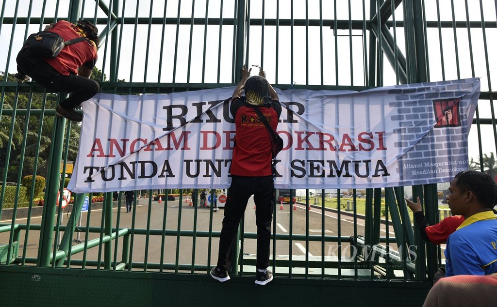 Peserta aksi memasang spanduk di pintu masuk Gedung DPR, Senayan, Jakarta, dalam unjuk rasa menolak Rancangan Kitab Undang-undang Hukum Pidana (RKUHP) berlangsung di depan Gedung MPR/DPR/DPD, Senayan, Jakarta, Senin (16/9/2019). 