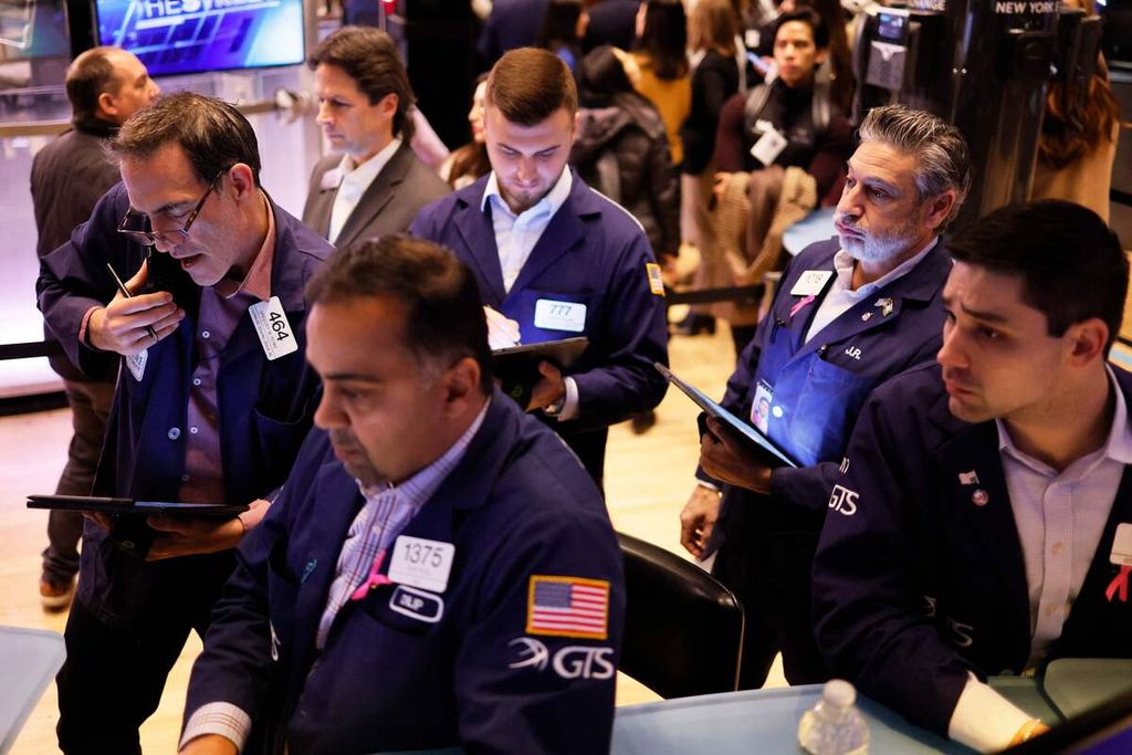 Para trader bekerja di lantai Bursa Efek New York pada perdagangan pagi di New York City, AS, 1 Desember 2023. 