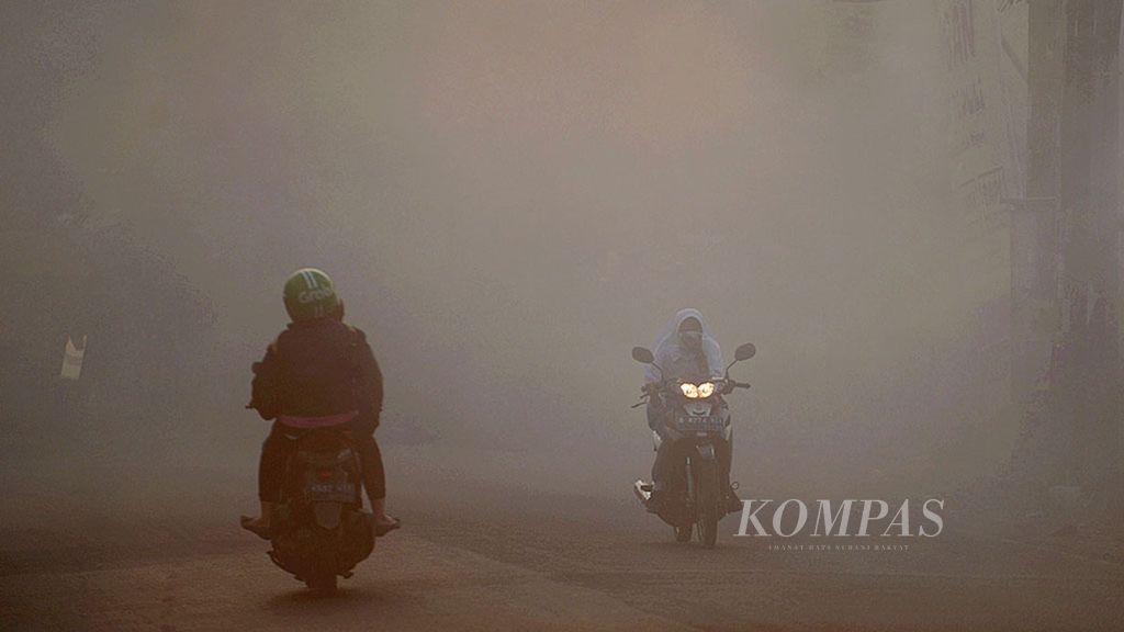 Menembus Asap - Pengendara menembus asap pembakaran sampah di Jalan Ceger Raya, Pondok Aren, Tangerang Selatan, Banten, Senin (28/8). 