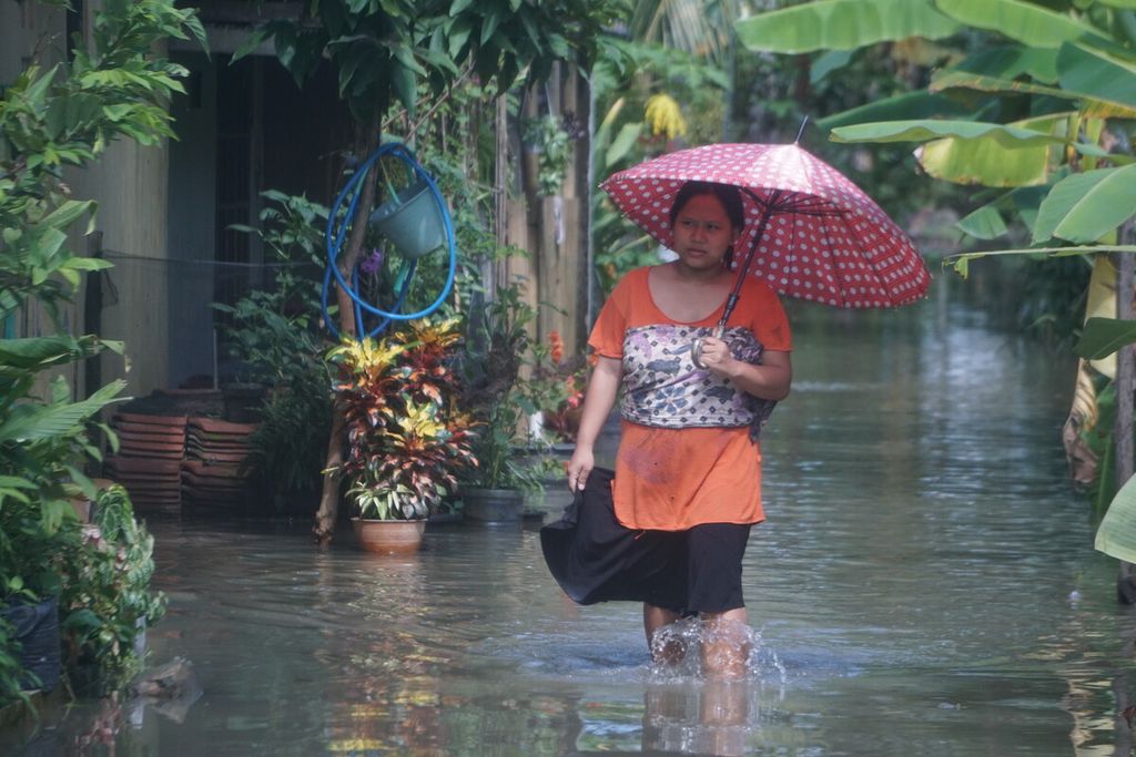 Ilustrasi: Warga melintasi banjir di Kawunganten, Cilacap, Jawa Tengah, Sabtu (8/10/2022). Di Cilacap banjir melanda 3 kecamatan, 213 keluarga atau 852 orang kebanjiran.