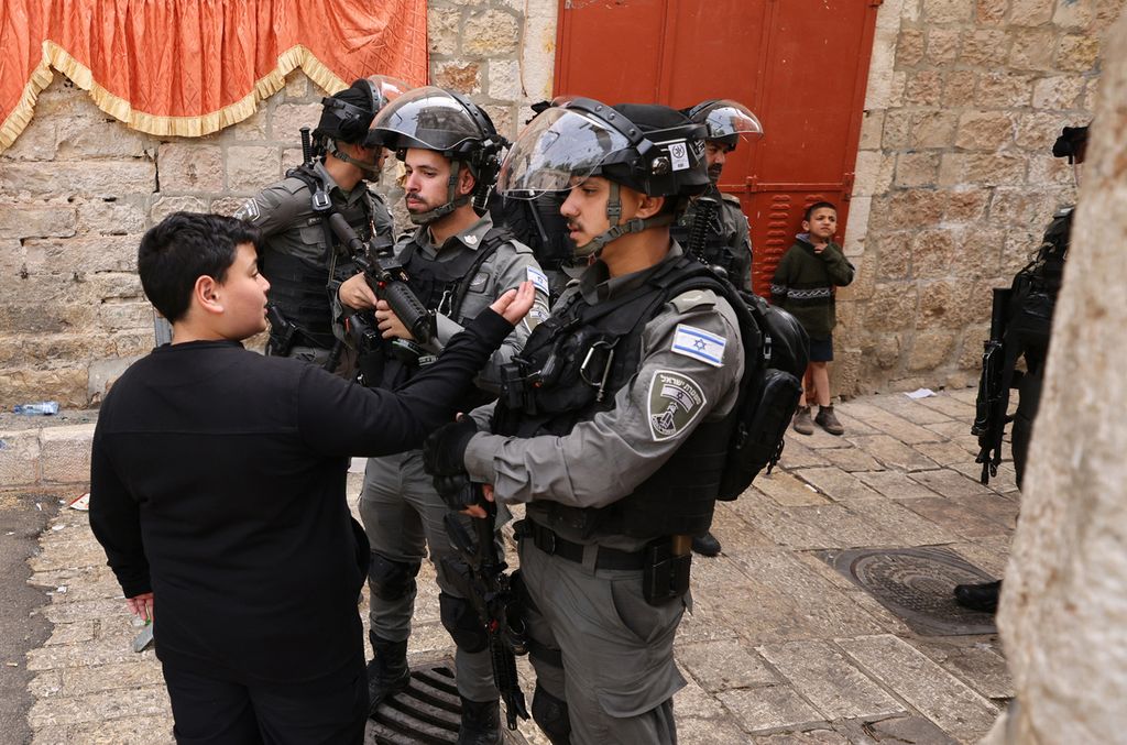 Seorang anak Palestina tengah ditanya oleh aparat keamanan Israel yang berjaga di Kota Tua Jerussalem, Minggu (17/4). Meski mendapat kecaman dari banyak pihak, Pemerintah Israel tetap melakukan operasi keamanan untuk meredam situasi di sekitar kompleks Mesjid Al Aqsa. 