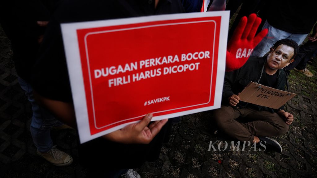 Seorang aktivis antikorupsi yang bergabung dalam Koalisi Masyarakat Sipil Antikorupsi mengenakan topeng bergambar wajah Ketua KPK Firli Bahuri saat menggelar aksi Save KPK di depan Gedung Komisi Pemberantasan Korupsi, Jakarta, Senin (10/4/2023).