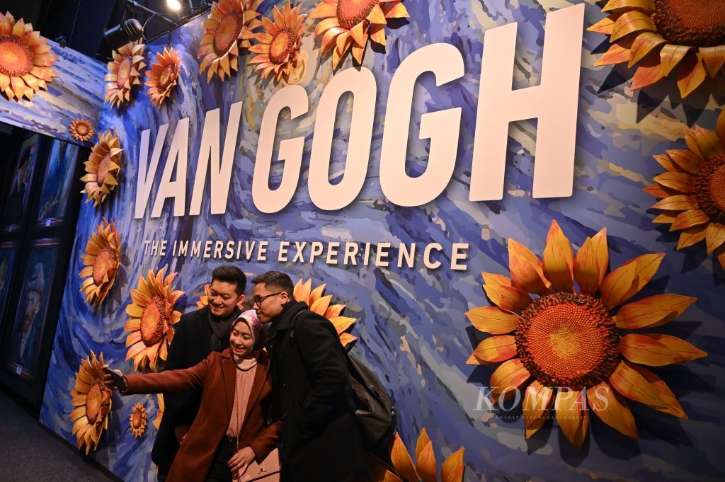 Berfoto di depan gerbang masuk pameran interaktif  Van Gogh–the Immersive Experience di London, Inggris, Jumat (1/4). Melalui pameran tiga dimensi ini, pengunjung diajak mengenal sisi lain sang pelukis sekaligus menari bersama imajinasi Van Gogh.