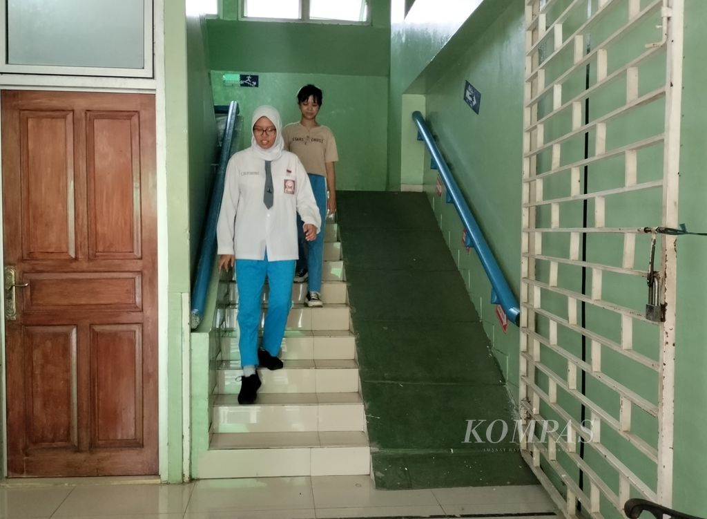 Siswa SMAN 68 Jakarta, Kamis (9/11/2023), melintasi anak tangga yang di sampingnya disediakan <i>ramp</i> untuk penyandang disabilitas. Sekolah ini menjalankan pendidikan inklusif yang menerima beragam anak berkebutuhan khusus untuk belajar bersama siswa sekolah reguler.