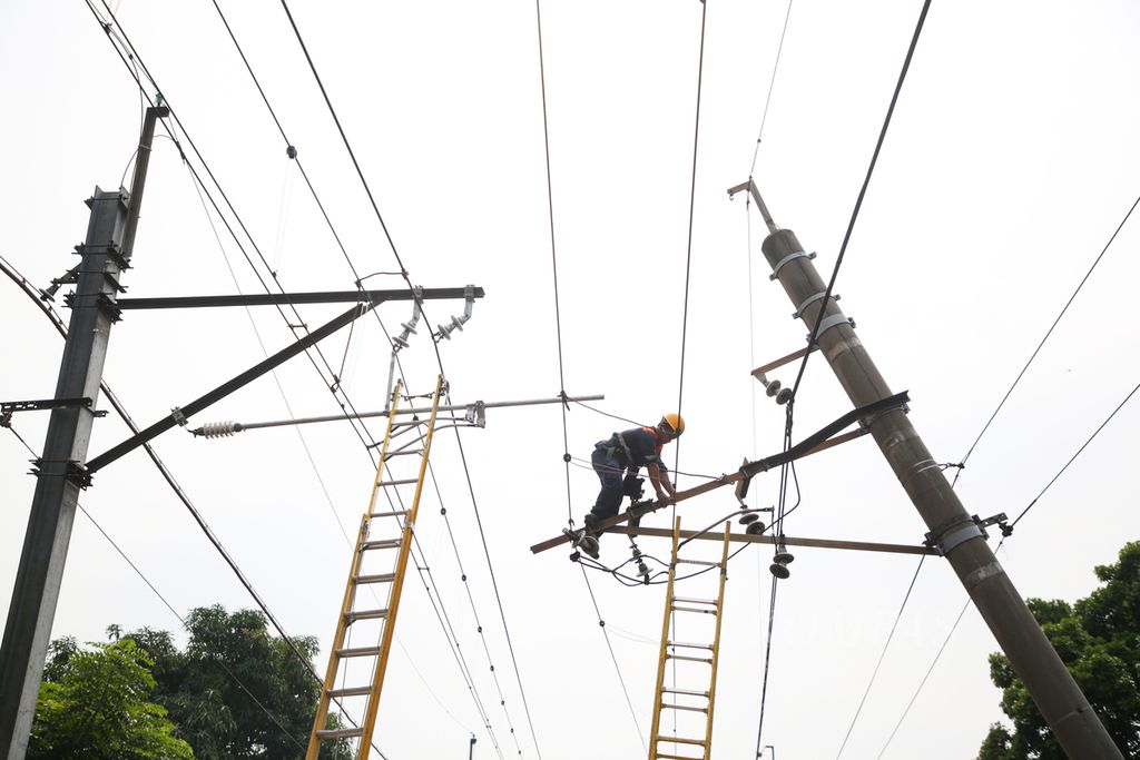 Petugas memperbaiki jaringan listrik aliran atas kereta komuter yang terganggu karena tiangnya ditabrak truk di jalan Bintaro Permai, Kecamatan Pesanggrahan, Jakarta Selatan, Selasa (25/7/2023).