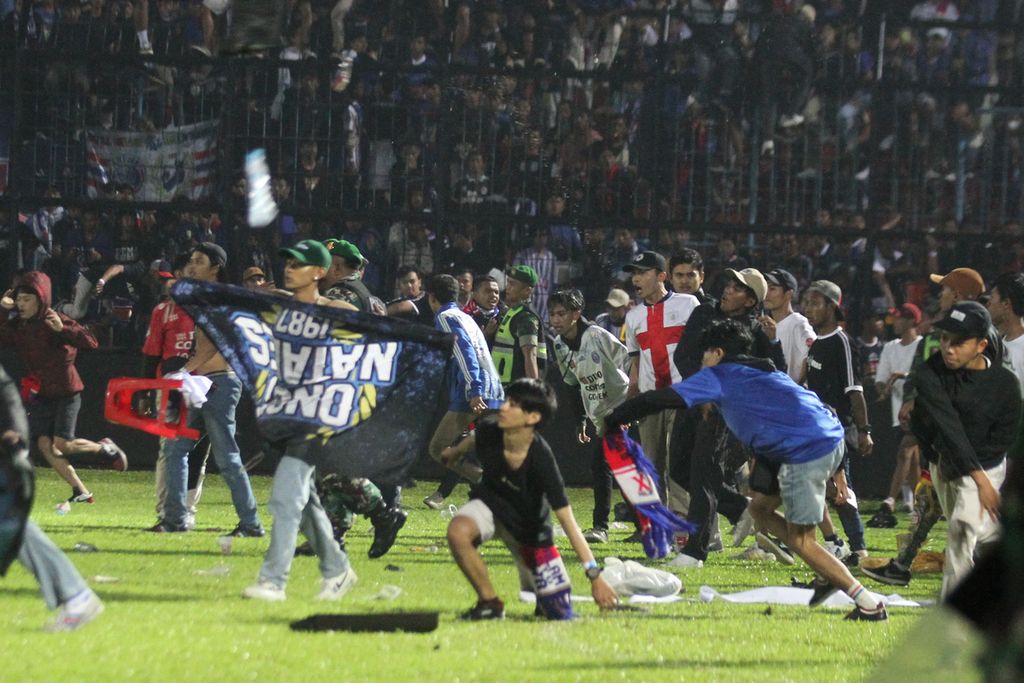 Arema FC supporters enter the field after the team they support lost to Persebaya in the BRI Liga 1 soccer match at Kanjuruhan Stadium, Malang, on Saturday (1/10/2022).