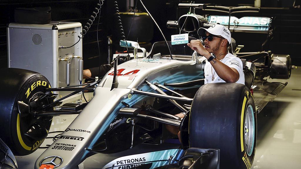 Pebalap Mercedes,  Lewis Hamilton,  memeriksa kabin mobil F1 yang akan dia pacu pada sesi latihan di Sirkuit Autodromo Hermanos Rodriguez, Mexico, Meksiko, Kamis (26/10). Pebalap Inggris itu hanya perlu finis kelima pada balapan seri Meksiko, Minggu (29/10), untuk meraih gelar juara dunia F1.