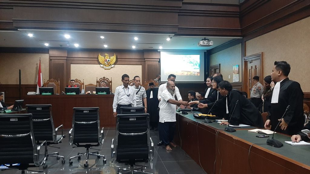 Terdakwa Lukas Enembe bersalaman dengan tim kuasa hukumnya sebelum agenda pembacaan putusan sela di Pengadilan Tindak Pidana Korupsi, Jakarta, Senin, (26/6/2023). 