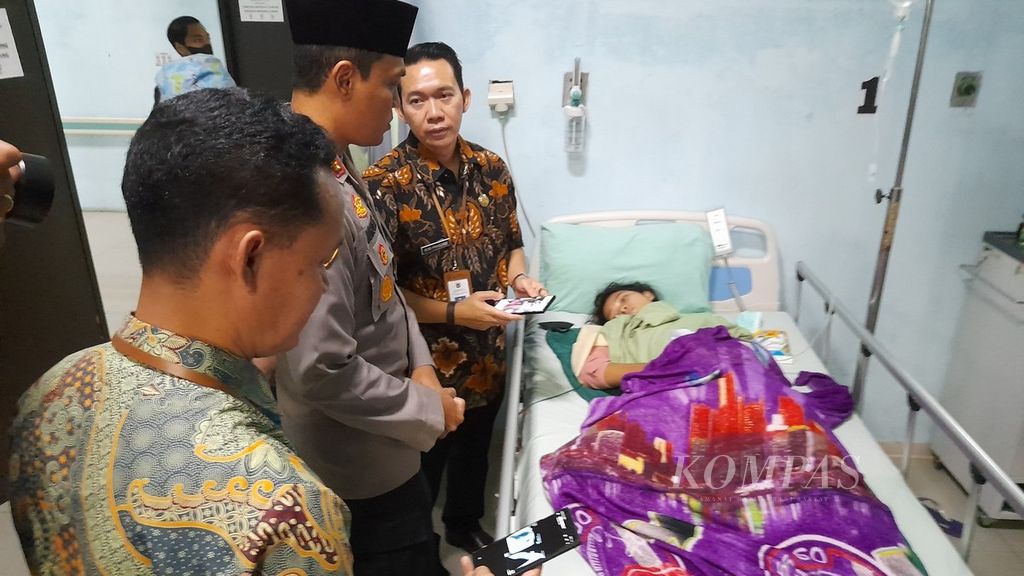 Kepala Kepolisian Resor Malang Ajun Komisaris Besar Putu Kholis Aryana (tengah) menjenguk Lilik (15), salah seorang korban Tragedi Kanjuruhan yang baru saja menjalani operasi akibat patah tulang lengan kanan di RSUD Kanjuruhan, Malang, Jawa Timur, Jumat (6/1/2023).