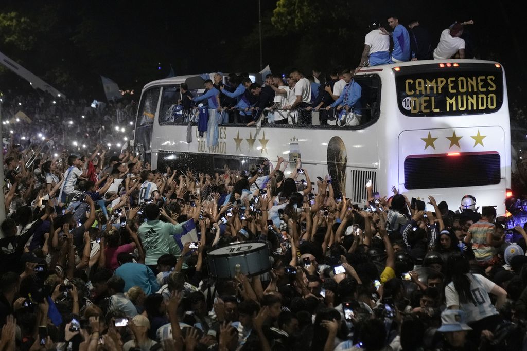 Fans menyambut pulang para pemain tim sepak bola Argentina yang menjuarai Piala Dunia setelah mereka mendarat di bandara Ezeiza di Buenos Aires, Argentina, Selasa, 20 Desember 2022. (AP Photo/Rodrigo Abd)