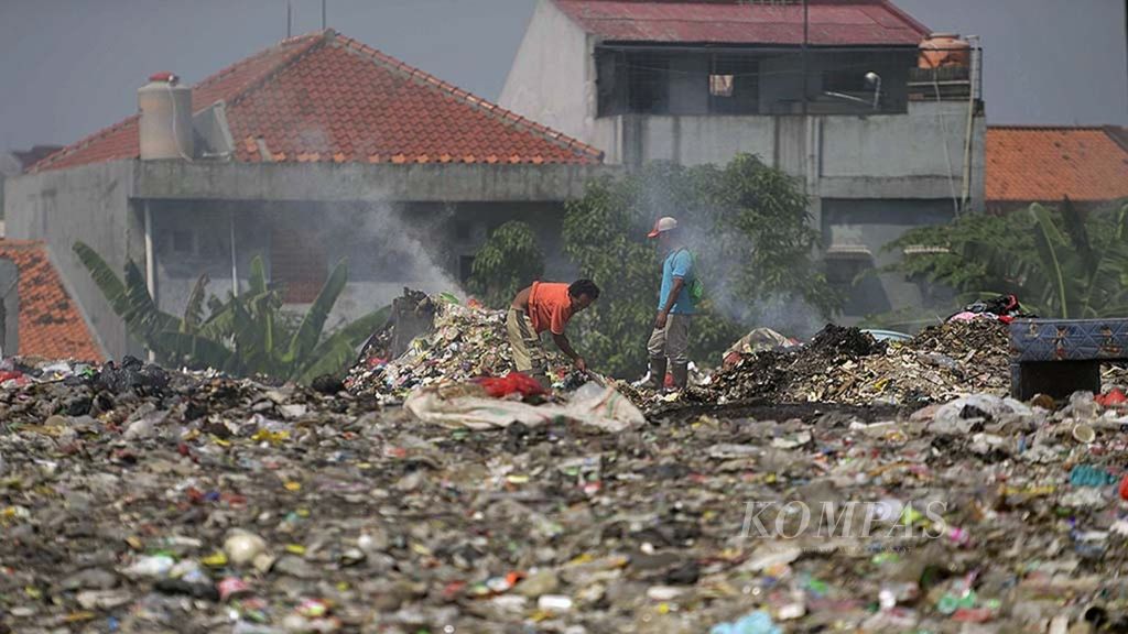 Warga membakar sampah di sebuah tanah kosong yang dijadikan tempat pembuangan sampah di kawasan Pondok Karya, Pondok Aren, Tangerang Selatan, Banten, Senin (19/6/2017).