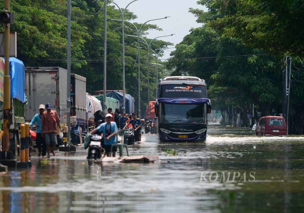A bus attempted to push through the flooding that is still flooding the Demak-Kudus Pantura route in Karangtengah District, Demak Regency, Central Java on Thursday (15/2/2024). The flood, which occurred a week after the breach of the Wulan River embankment, has not yet receded in some villages in Karanganyar and Karangtengah districts.