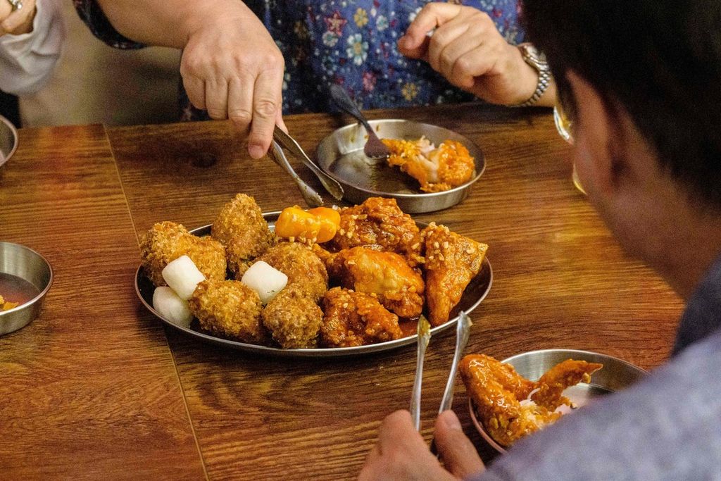 Pelanggan menikmati santapan ayam goreng yang disiapkan oleh robot di restoran "Robert Chicken" di Seoul, Korea Selatan, 13 Juni 2023. 