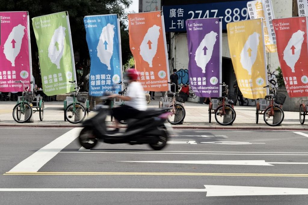 Seorang pengendara sepeda motor melewati bendera prokemerdekaan Taiwan di Taipei, ibu kota Taiwan, 6 Agustus 2022. 