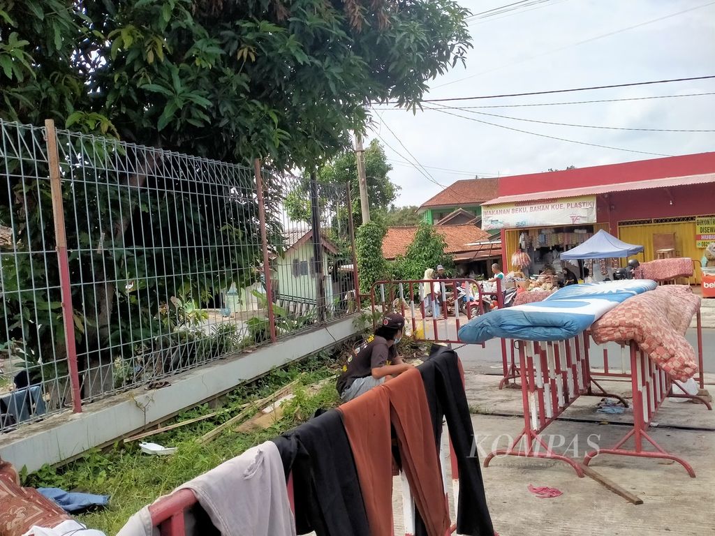 Warga yang terdampak banjir menjemur pakaian dan kasur di pinggir jalan di Bandar Lampung pada Senin (26/2/2024). 
