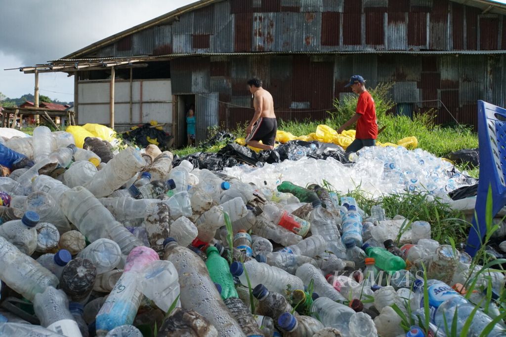 Petugas di Bank Sampah Induk Mapalus Kota Tomohon, Sulawesi Utara, melintas di antara tumpukan sampah plastik. Mayoritas sampah plastik di bank sampah tersebut berasal dari Manado, Sulawesi Utara.