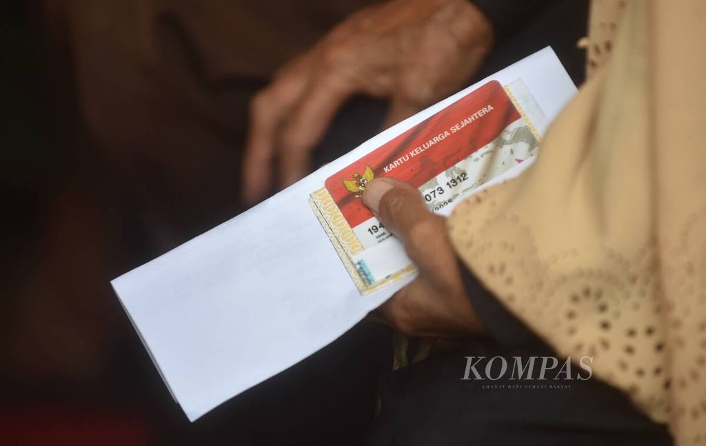 Warga menunggu waktu penyaluran bantuan Program Keluarga Harapan, Bantuan Pangan Non-Tunai, dan Bantuan Langsung Tunai (BLT) minyak goreng di Kantor Kecamatan Rungkut, Kota Surabaya, Jawa Timur, Sabtu (16/4/2022). 