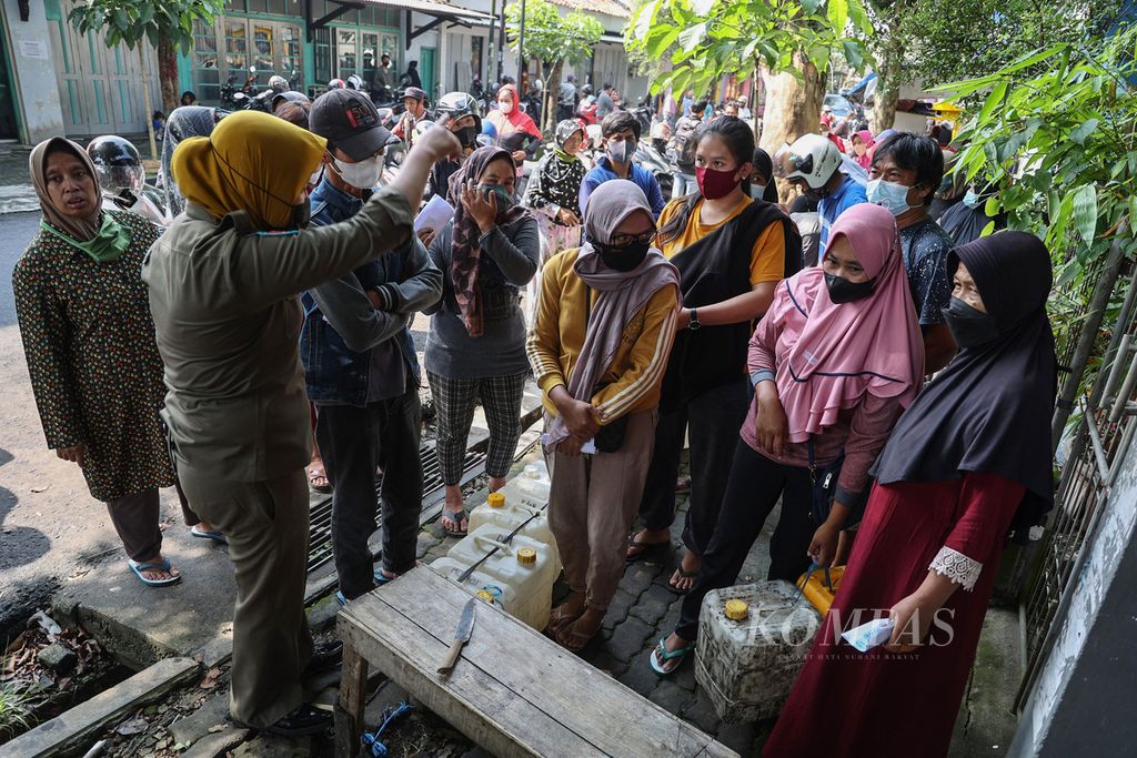Petugas Satpol PP mengatur pembeli minyak goreng curah yang mengantre di salah satu penyalur di ibu kota Kabupaten Temanggung, Jawa Tengah, Kamis (14/4/2022). 