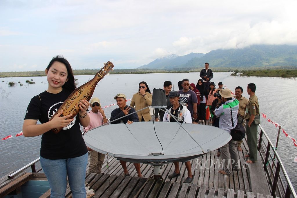 Salah satu seniman asal Malaysia, Elizabeth Bungan, memainkan alat musik sape’ di atas kapal bandong saat susur Danau Sentarum, Kabupaten Kapuas Hulu. Kalimantan Barat, Kamis (26/10). 