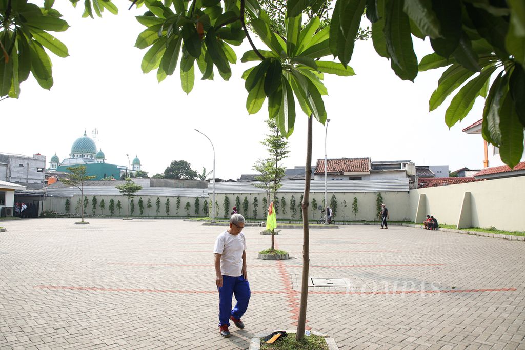 Seorang lanjut usia berjemur berjalan mengelilingi area parkir gedung pertemuan di kawasan Larangan, Kota Tangerang, Banten, Jumat (4/6/2021). 