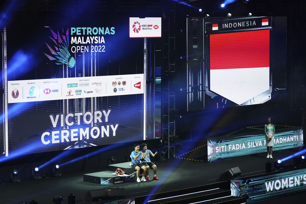 Apriyani Rahayu, right, and Siti Fadia Silva Ramadanti of Indonesia celebrate on the podium after defeating China's Zhang Shu Xian and Zheng Yu in their women's doubles final match at the Malaysia Open badminton tournament at Bukit Jalil Axiata Arena in Kuala Lumpur, Malaysia, Sunday (3/7/2022).