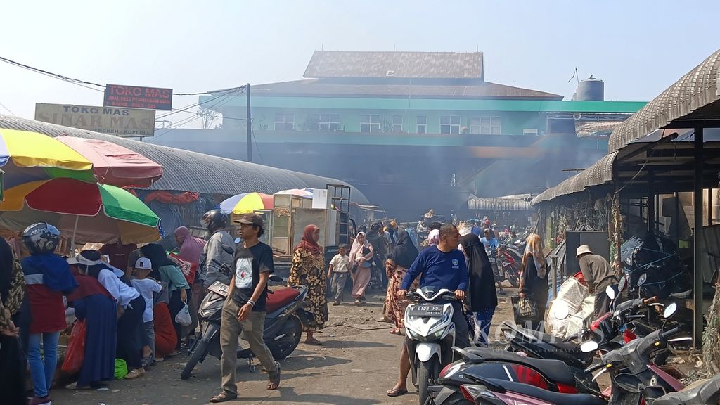 Pasar Leuwiliang, Kabupaten Bogor, Jawa Barat, Kamis (28/9/2023), tetap beroperasi meski di bagian dalam dan belakangnya tampak Kepulan asap dari kebakaran.