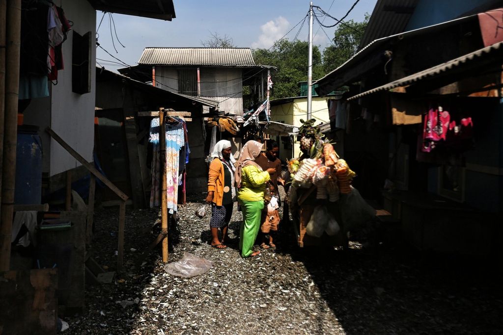 Warga penghuni kawasan permukiman padat penduduk Muara Angke, Penjaringan, Jakarta Utara, sedang berbelanja kebutuhan sehari-hari kepada penjaja sayur keliling, Jumat (7/1/2022). 