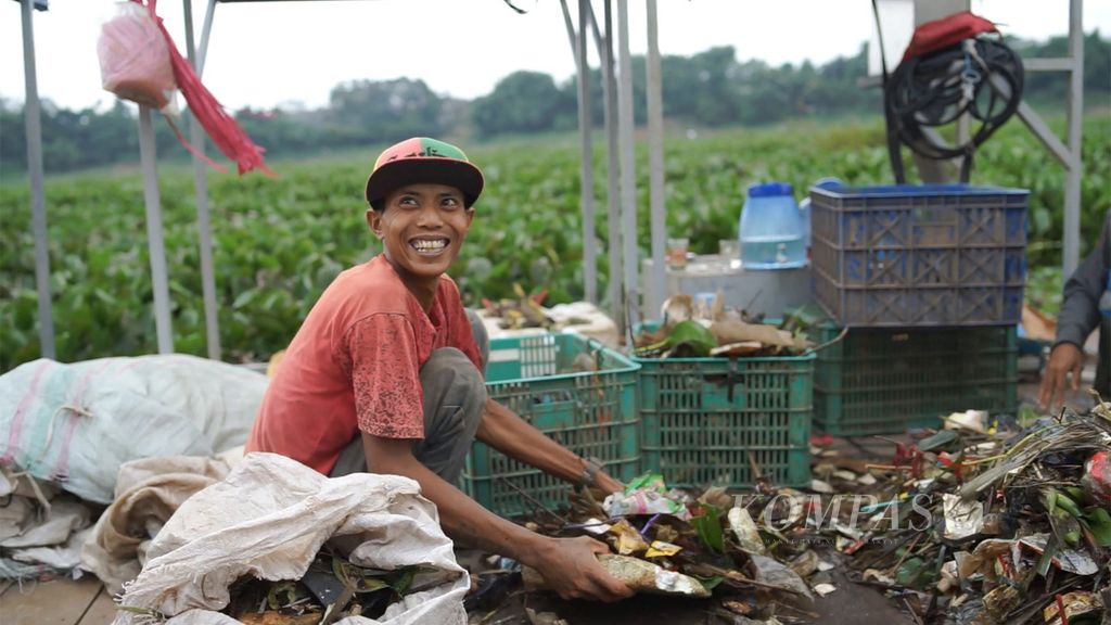Rudi (24) memilah sampah yang diangkat dari permukaan Waduk Saguling, Kabupaten Bandung Barat, Jawa Barat pada Selasa (7/2/2023). Rudi sudah enam tahun mencari nafkah sebagai pemulung di Waduk Saguling, meneruskan jejak ayahnya.