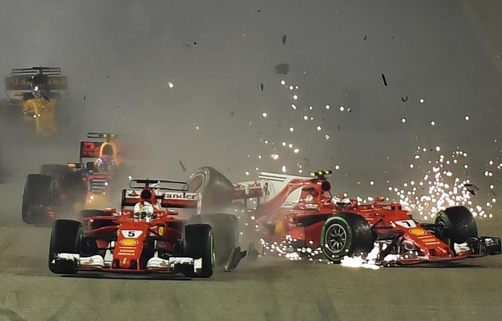 Dua pebalap  Ferrari, Kimi Raikkonen (kanan), dan Sebastian Vettel seusai bertabrakan dan harus keluar dari balapan Formula 1 Seri Singapura di Sirkuit Marina Bay Street, Minggu (17/9) malam. Dalam lomba ini, Lewis Hamilton meraih podium tertinggi.