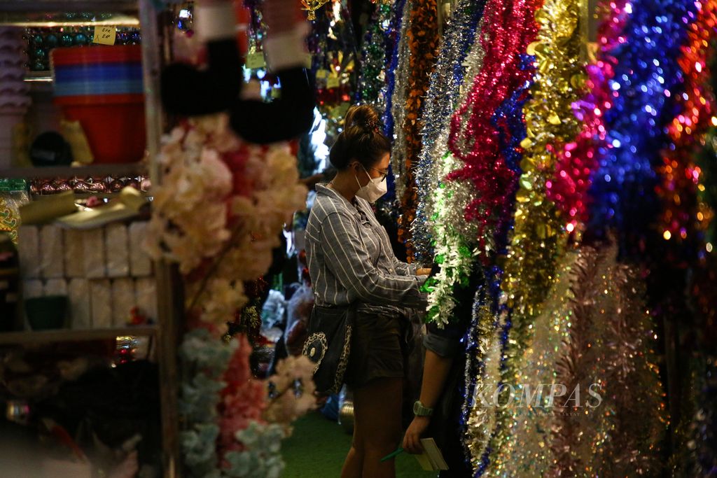 Pengunjung memilih berbagai jenis ornamen Natal di salah satu toko di Pasar Asemka, Jakarta Barat, Minggu (12/12/2021). Pedagang mengakui, jelang perayaan Natal, para konsumen lebih banyak berbelanja ornamen Natal jika dibanding dengan pembelian pohon Natal.