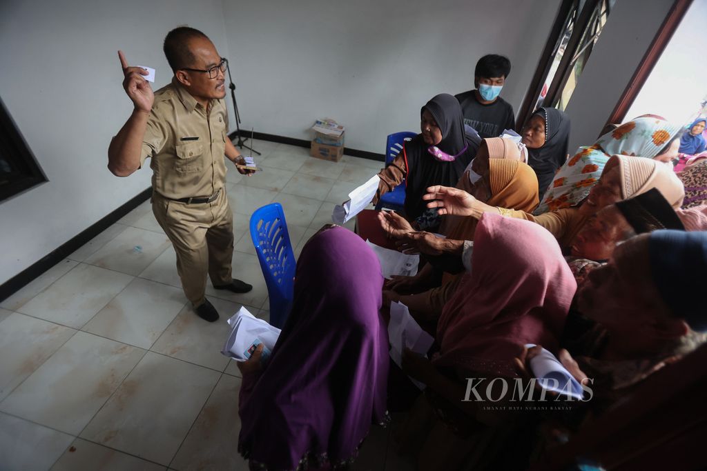 Warga berebut nomor antrean untuk menerima bantuan uang tunai di Balai Desa Kaponan, Kecamatan Pakis, Magelang, Jawa Tengah, Senin (28/11/2022).  