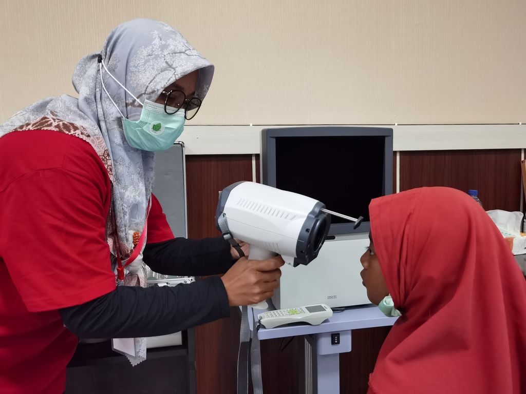 Tim Rumah Sakit Mata NTB memeriksa kondisi mata salah satu dari 300 anak penerima bantuan kacamata dari pembaca Harian Kompas dalam peringatan Hari Anak Nasional 2022 di Selong, Lombok Timur, Nusa Tenggara Barat, Senin (1/8/2022).