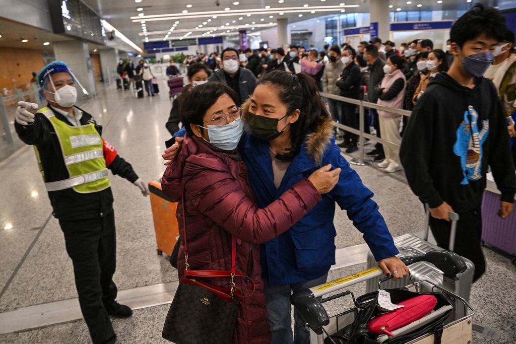 Seorang penumpang (kanan) menerima pelukan saat meninggalkan area kedatangan penerbangan internasional di Bandara Internasional Shanghai Pudong, Shanghai, Minggu (8/1/2023). China mencabut persyaratan karantina untuk pelancong yang masuk ke China. 
