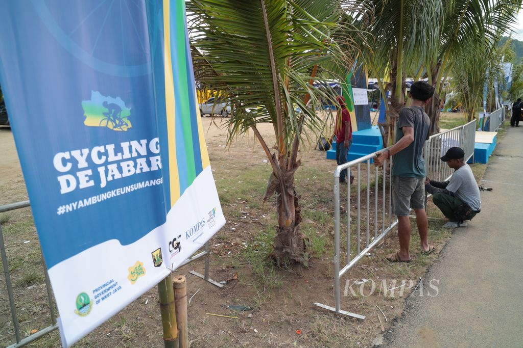 Pekerja merampungkan persiapan <i>venue</i> untuk tempat start Cycling de Jabar 2023 etape pertama di kawasan Pantai Palangpang, Sukabumi, Jawa Barat, Jumat (7/7/2023). 