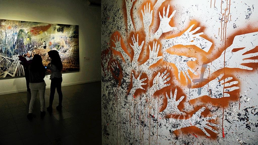 Pengunjung berswafoto di hadapan lukisan "Jejak Cahaya" karya perupa S Dwi Stya Acong dalam Pameran Gambar Cadas Indonesia bertajuk Wimba Kala, Senin (8/5/2017), di Galeri Nasional Indonesia, Jakarta. 