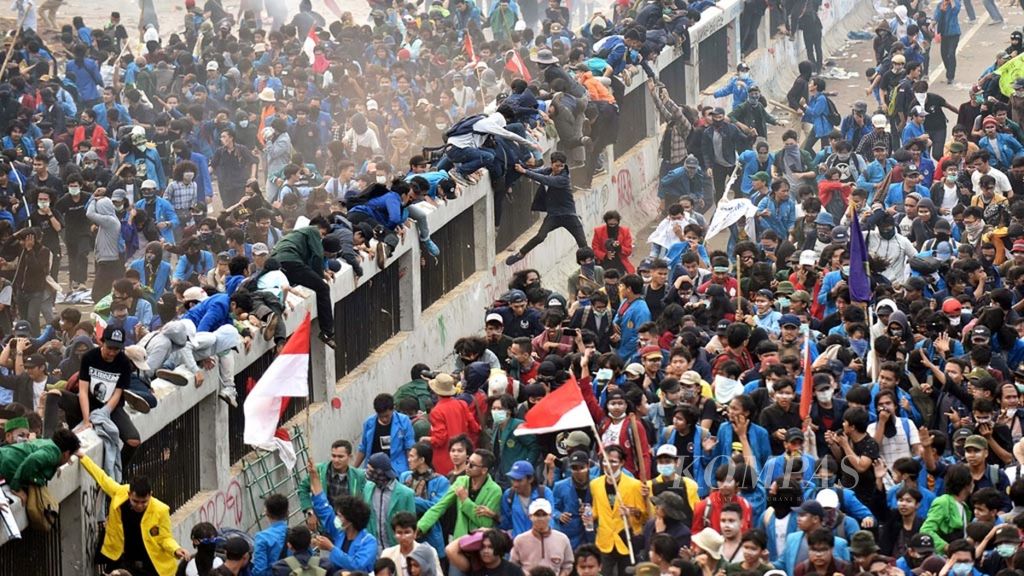 Para mahasiswa berusaha menghindari gas air mata yang ditembakkan polisi saat berunjuk rasa di depan Kompleks Parlemen, Senayan, Jakarta, Selasa (24/9/2019). Mereka berunjuk rasa menuntut dibatalkannya pengesahan RKUHP dan sejumlah RUU kontroversial lainnya. 