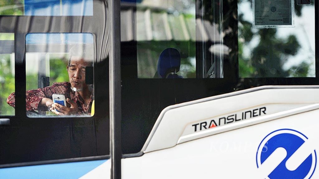 Pengemudi Transjakarta beristirahat di dalam bus saat tidak mengangkut penumpang di Jalan Galunggung, Jakarta, Senin (2/10/2017). 