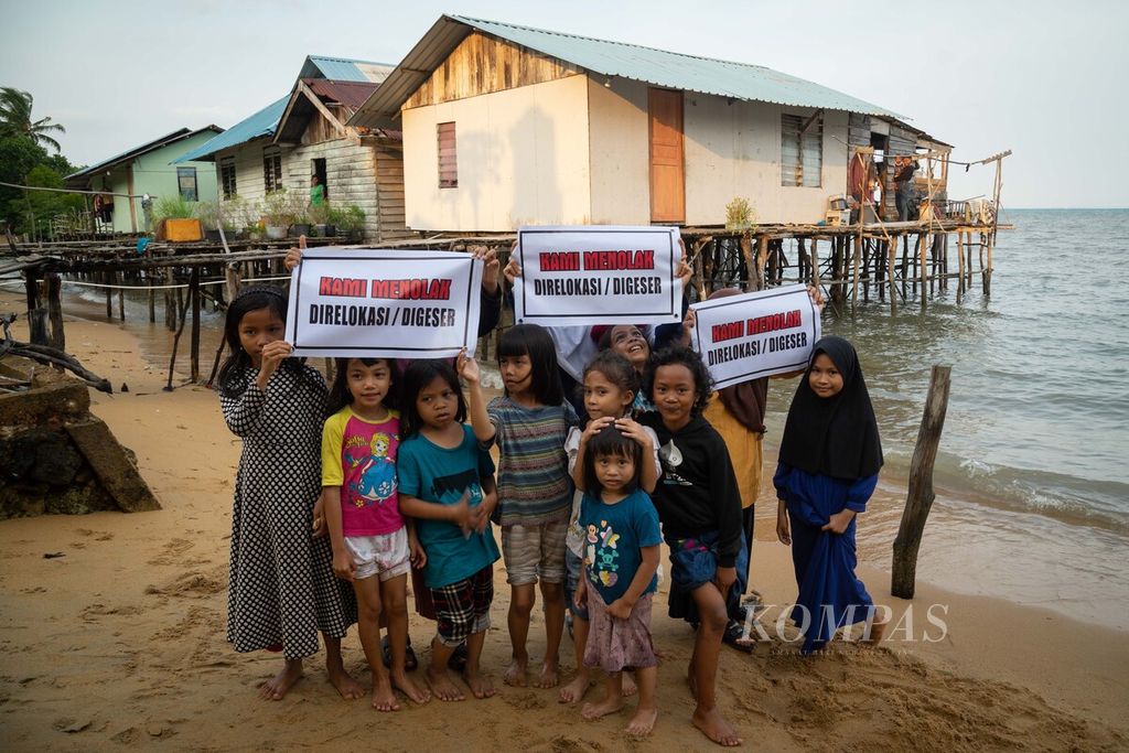 Anak-anak memegang spanduk penolakan relokasi di Kampung Pasir Merah, Pulau Rempang, Kecamatan Galang, Batam, Kepulauan Riau, Kamis (5/10/2023). 