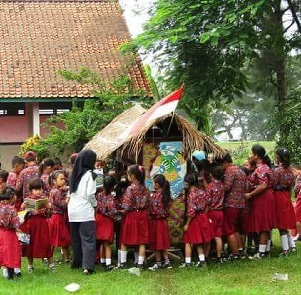 Murid-murid SD mengerubungi Pedati Pustaka milik Robianto untuk meminjam buku. Setiap hari Robianto berkeliling di desa-desa di Kabupaten Cirebon, Jawa Barat, untuk meminjamkan buku secara gratis kepada siapa saja yang mau membaca.