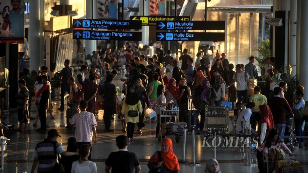  Penumpang pesawat meninggalkan pintu kedatangan Terminal 1 Bandara Internasional Soekarno-Hatta, Tangerang, Banten, Minggu (2/7/2017).