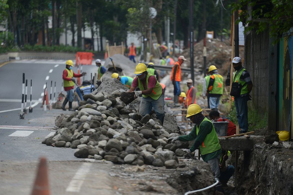 Pekerja menggarap proyek perbaikan saluran drainase program padat karya di tepi Jalan Soekarno-Hatta, Magelang, Jawa Tengah, Rabu (14/7/2021). Keberadaan program padat karya membantu masyarakat memperoleh pendapatan.
