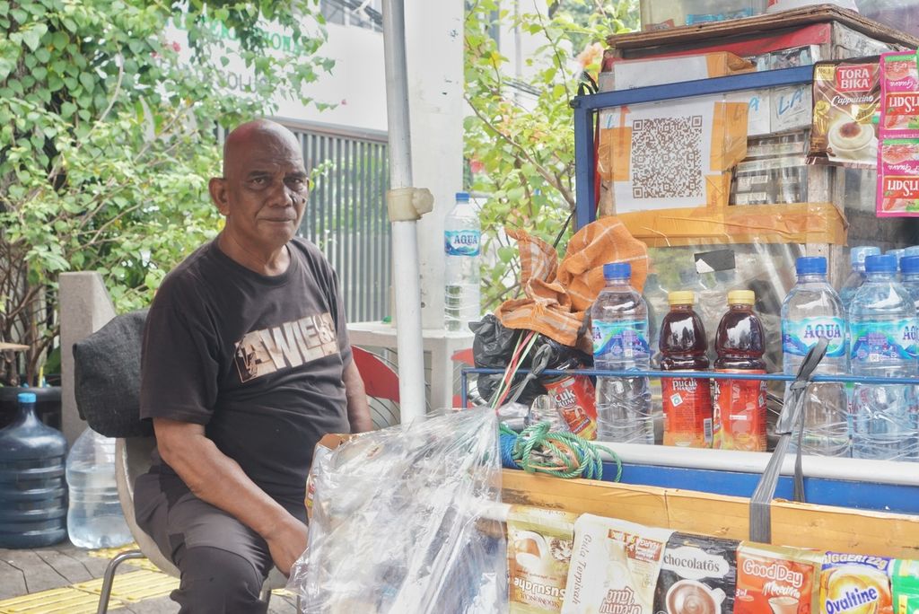 Herianto (55) menjaga barang dagangannya di kawasan Blok M, Jakarta, Selasa (2/4/2024).